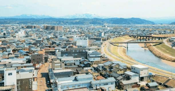 三条市のまち並み、三条市内を流れる五十嵐川（信濃川の支流）と奥に見えるアウトドアを楽しめる下田郷